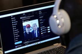 A viewer watches Elon Musk's interview with Donald Trump on X on Monday. (Adam Gray/Reuters)