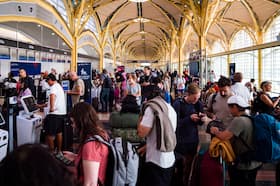 Passengers are seen waiting at Reagan National Airport on July 19 as technical issues grounded many flights. (Allison Robbert/The Washington Post)