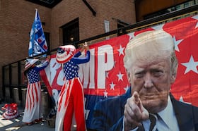 Supporters of former president Donald Trump hang a banner outside the Republican National Convention in Milwaukee on Wednesday. (Spencer Platt/Getty Images)