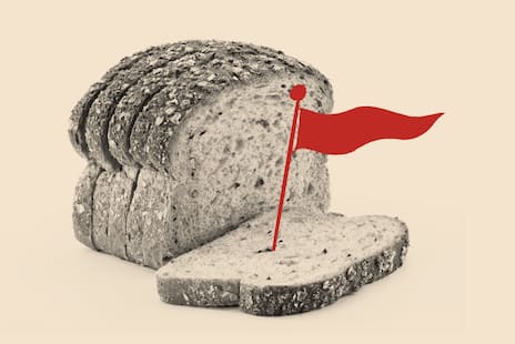 A photo illustration that shows a loaf of sliced bread with a red flag coming out of one slice.