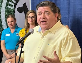 Illinois Gov. J.B. Pritzker (D) prepares to unveil the Butter Cow, at the Illinois State Fair on Aug. 7 in Springfield, Ill.