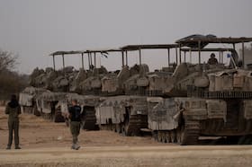 Israeli armored vehicles are parked in an area next to the Israeli-Gaza border, as seen from southern Israel on Thursday. (Leo Correa/AP)